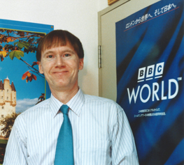 The author beside a 1995 BBC World poster for Japan